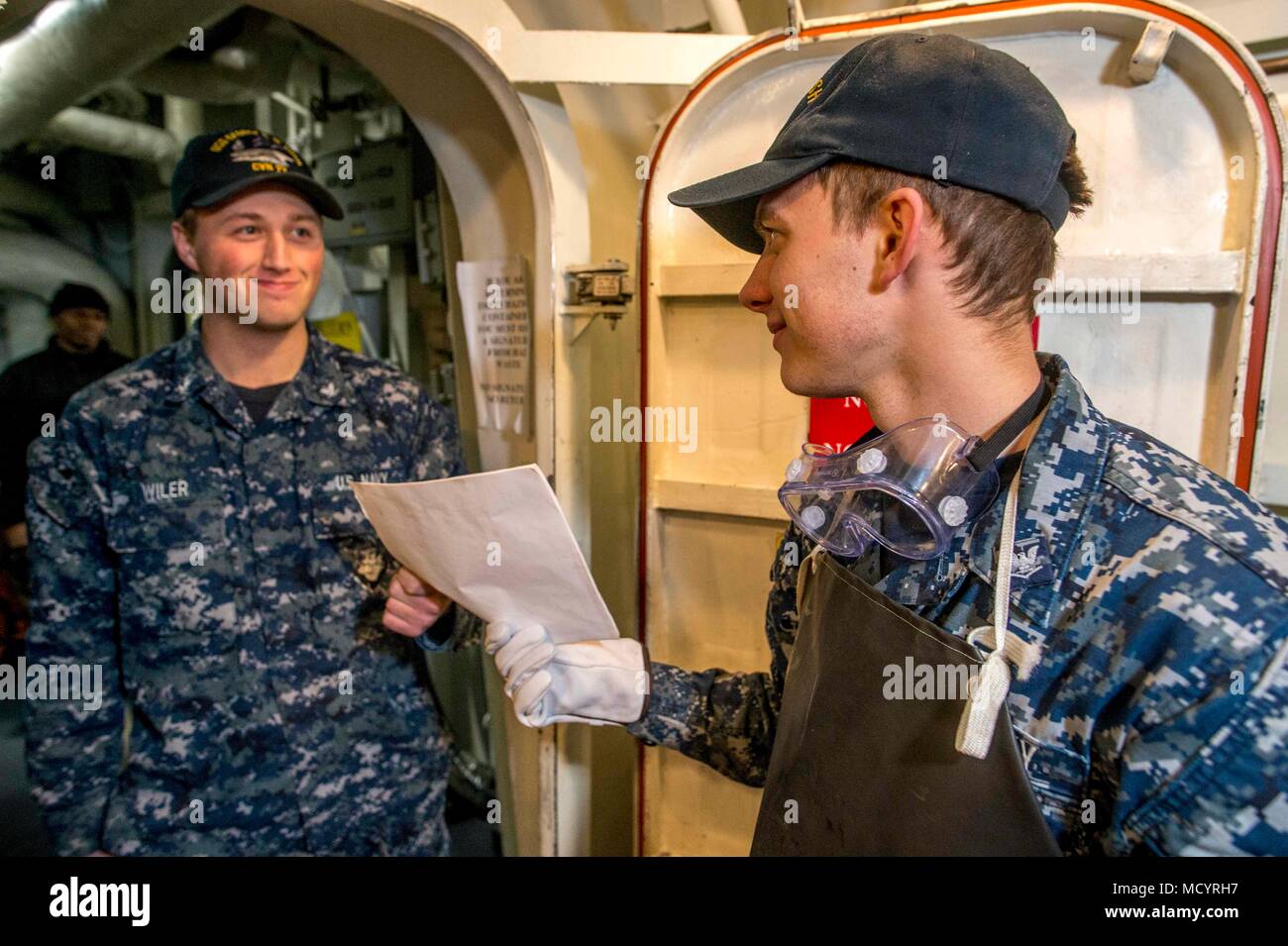 180305-N-NG136-0046 NORFOLK, Va (March 5, 2018) Operations Specialist 3rd Class Emmit Wiler, left, hands a hazardous material receipt to Operations Specialist 3rd Class Richard Walton aboard the aircraft carrier USS George H.W. Bush (CVN 77). The ship is in port in Norfolk, Virginia, undergoing the Maintenance Material Management (3M) Inspection. (U.S. Navy photo by Mass Communication Specialist 3rd Class Zachary P. Wickline) Stock Photo