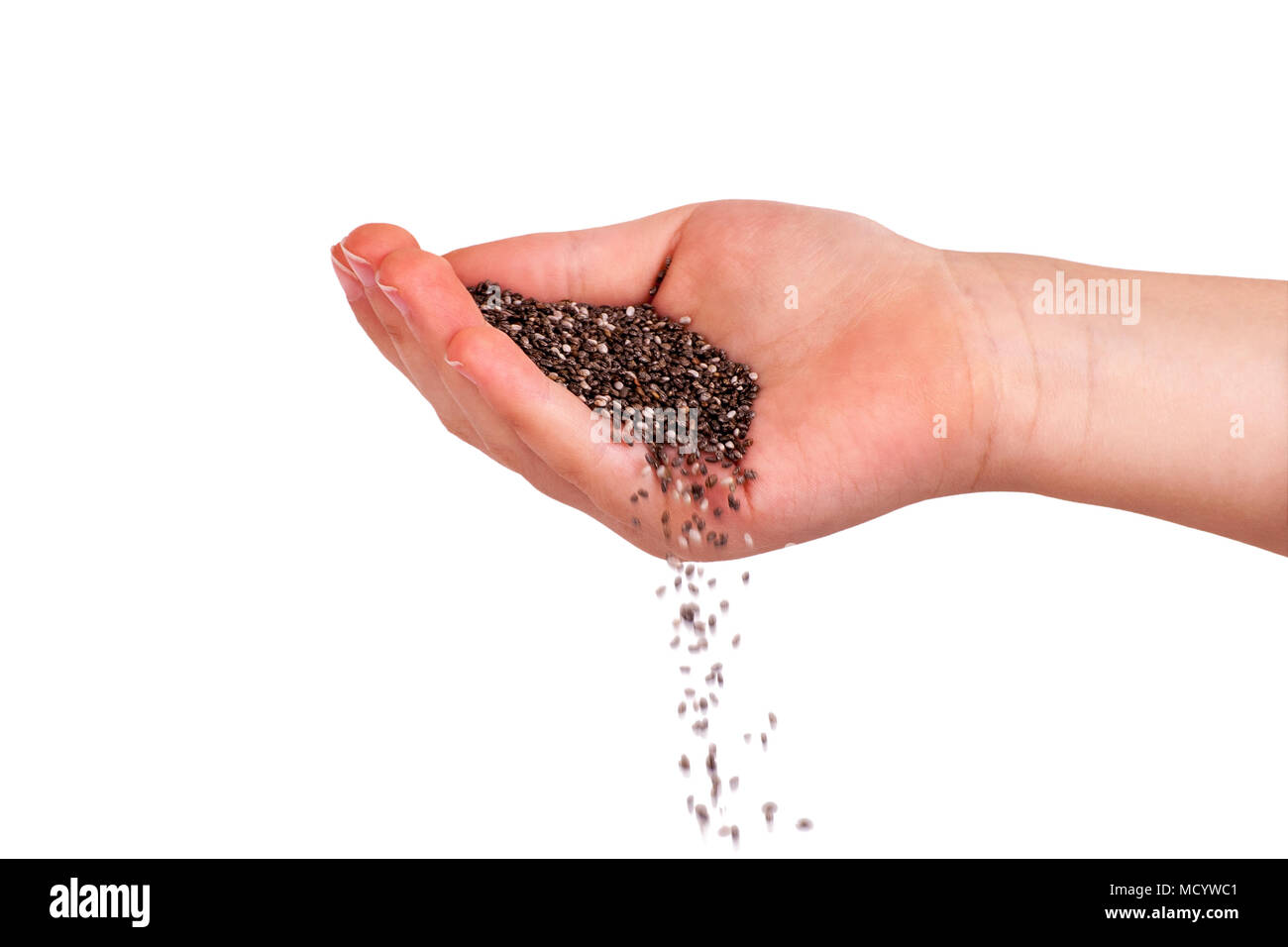 Chia seeds falling from hand. Isolated over white. Stock Photo