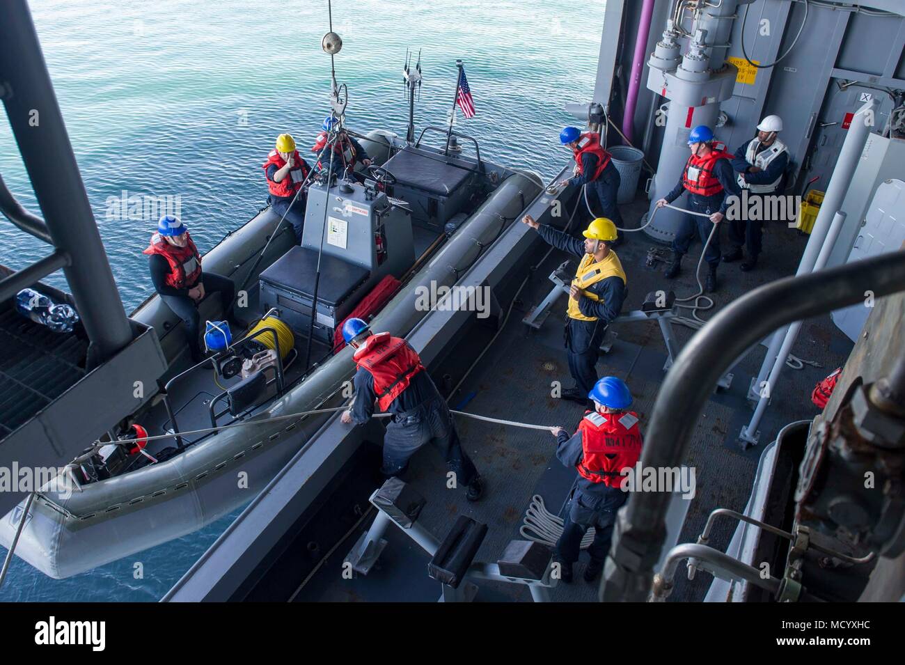 180306-N-ZS023-012 PACIFIC OCEAN (March 6, 2018) Sailors aboard the amphibious assault ship USS America (LHA 6) lower a rigid-hulled inflatable boat using the ship’s starboard davit. America is underway off the coast of southern California conducting an ammunitions offload prior to entering a planned maintenance availability period. (U.S. Navy photo by Mass Communication Specialist 3rd Class Vance Hand/Released) Stock Photo