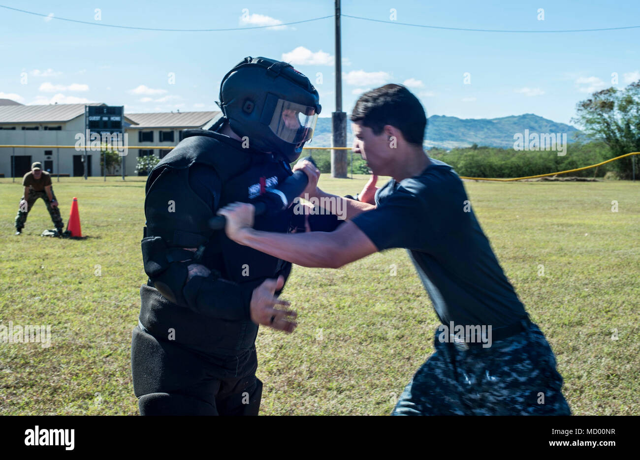 SANTA RITA, Guam ( March 9, 2018) Red Man, Gunner's Mate Seaman Blake day, receives a baton strike from Ship's Serviceman Seaman Roland Daigle, both assigned to the submarine tender USS Frank Cable (AS 40), as Daigle fights through stations during non-lethal weapons training, while under the effects of Oleoresin Capsicum, pepper spray, on Naval Base Guam, March 9. Frank Cable, forward-deployed to Guam, repairs, rearms and reprovisions deployed U.S. Naval Forces in the Indo-Pacific region.   (U.S. Navy photo by Mass Communication Specialist 3rd Class Alana Langdon/Released) Stock Photo