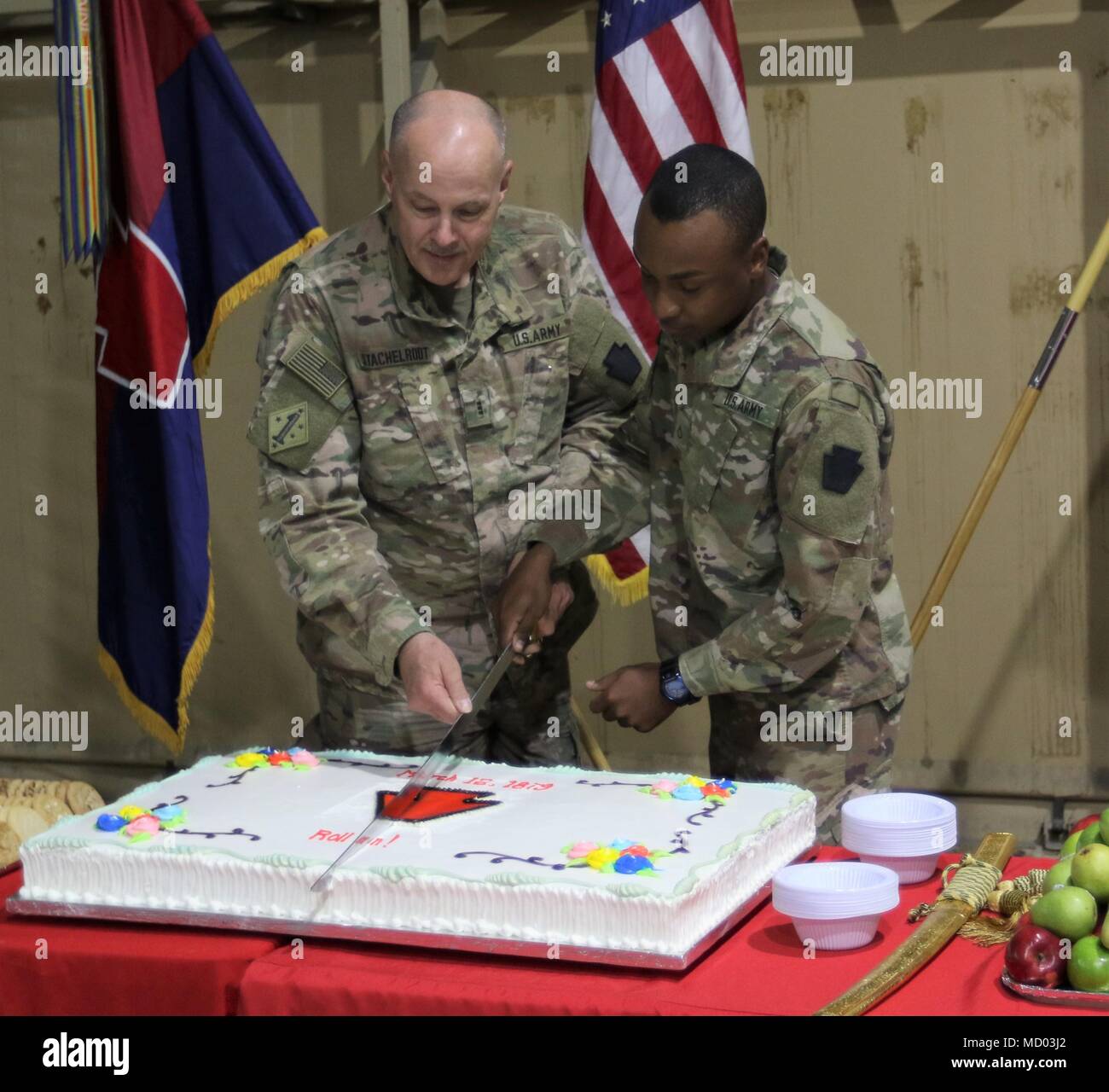 CAMP ARIFJAN, Kuwait – The oldest and youngest soldier of the 28th Infantry Division, respectively, celebrate the division’s birthday by cutting the cake on March 12, 2018.  The 28 ID is the longest continuously-serving division in the US Army, dating back to its creation on March 12, 1879. Stock Photo