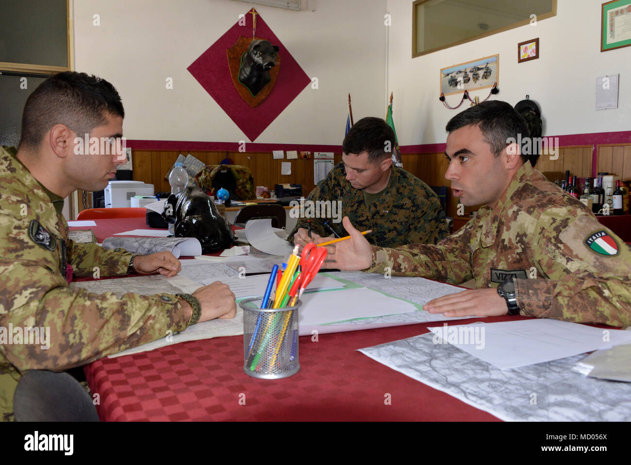 A Marine platoon commander with the Special Purpose Marine Air-Ground Task Force-Crisis Response-Africa, ground combat element, and an Italian platoon commander and a company commander of the 6th Bersaglieri Regiment finalize the insertion plan for a joint field exercise, March 6, 2018, in Trapani, Italy. SPMAGTF-CR-AF is deployed to conduct crisis-response and theater-security operations in Europe and Africa. (U.S. Marine Corps photo by Gunnery Sgt. Rebekka S. Heite/Released) Stock Photo
