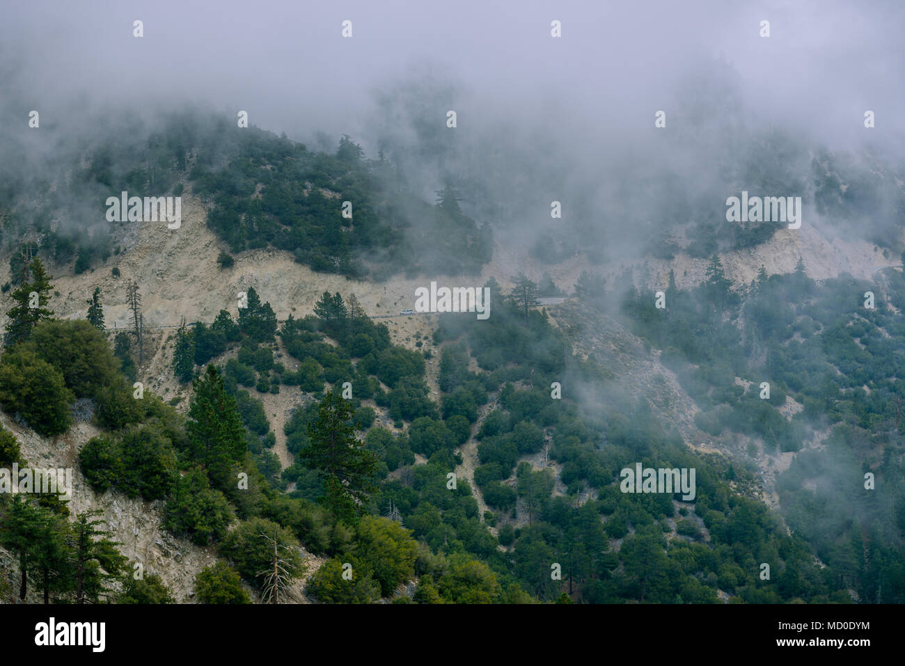 A highway passes through a mountain as a storm and heavy fog rolls in Stock Photo