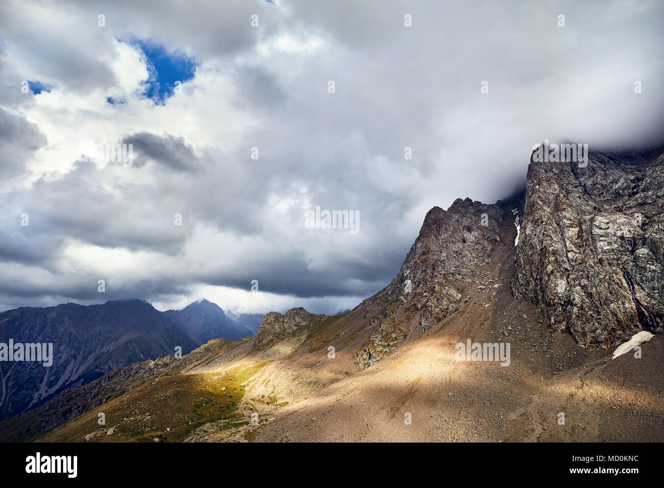Landscape of Mountain Valley with Rocks at grey overcast cloudy sky background Stock Photo