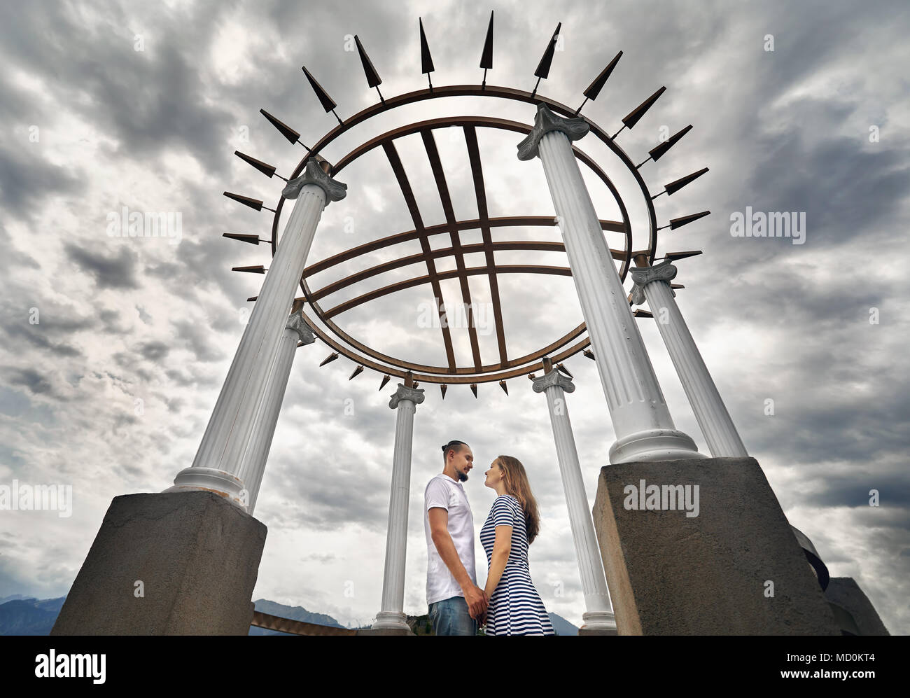 Happy couple in holding by hands in the house with roof in shape of ...