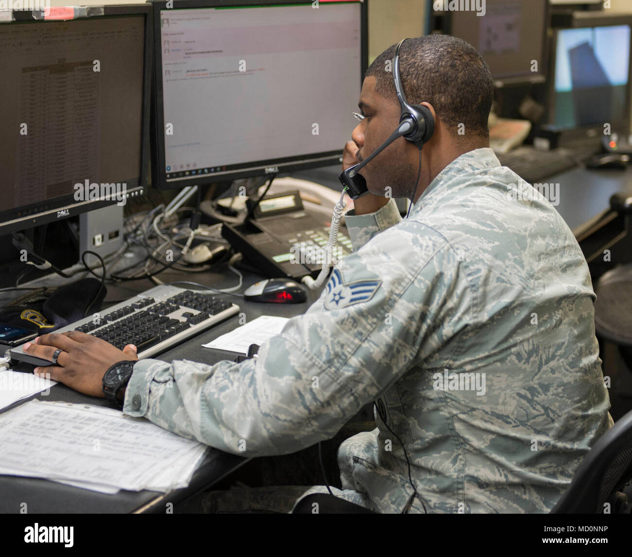 U.S. Air Force Senior Airman Joshua Thomas works as a base defense operations center controller March 29, 2018, at Kadena Air Base, Japan. BDOC serves as a centralized dispatch center, fielding incoming calls to the appropriate SFS members out in the field. Stock Photo