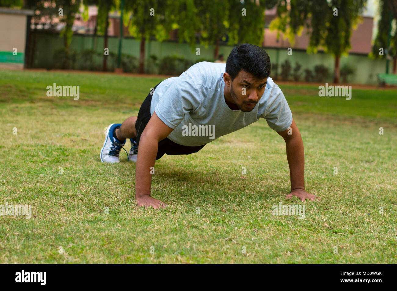 Young guy doing push ups in a park Stock Photo