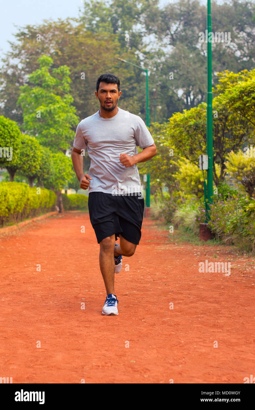 Young guy running on a jogging track Stock Photo
