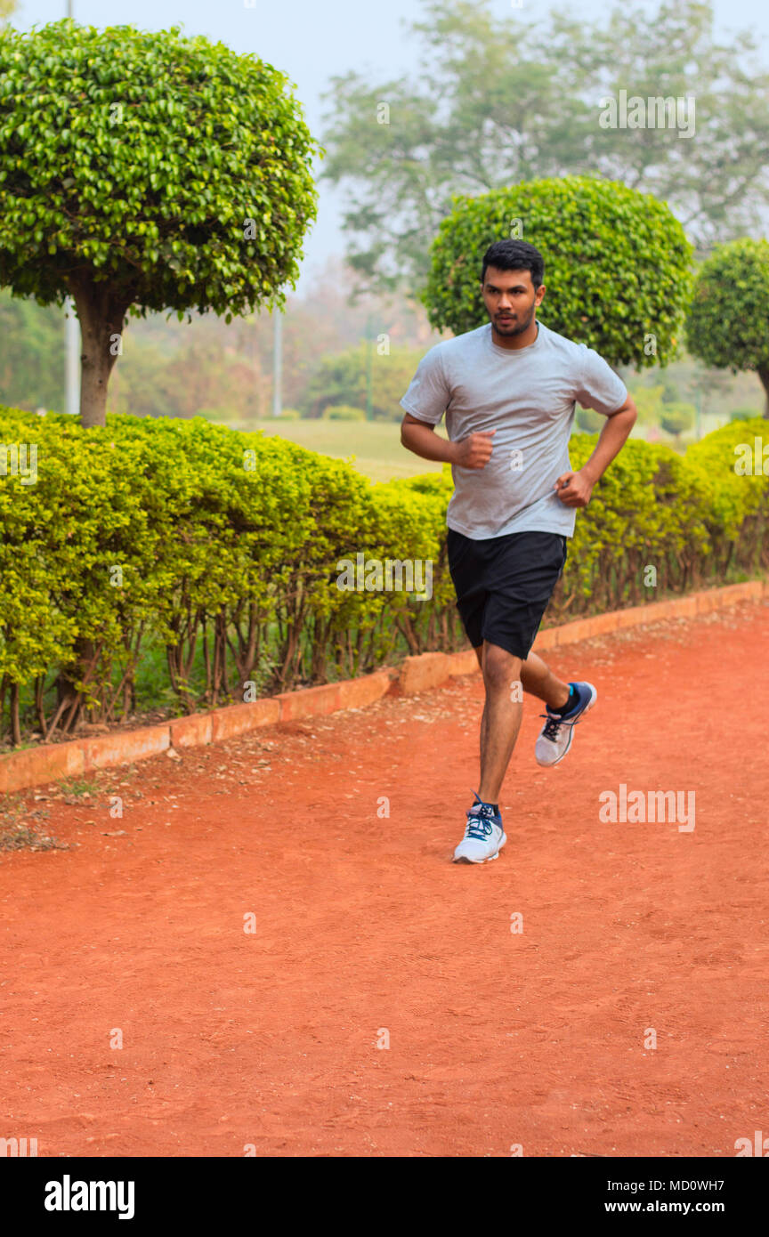 Young guy running on a jogging track Stock Photo