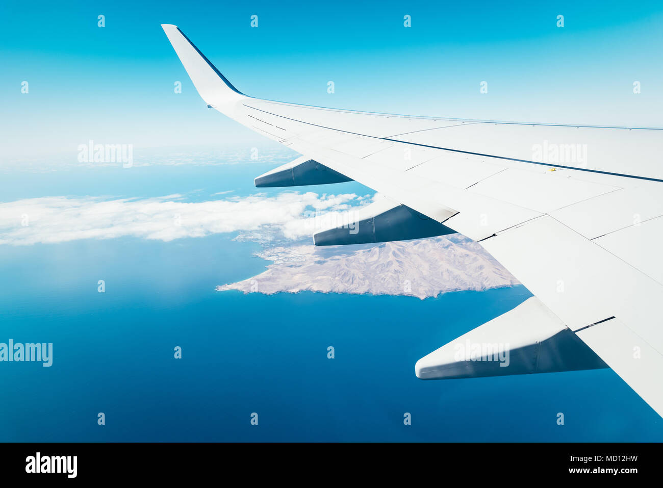 Wing of airplane above island. Traveling concept Stock Photo