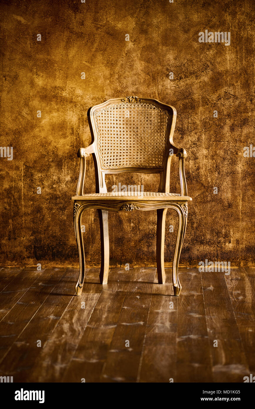 old chair on a brown wall background Stock Photo - Alamy
