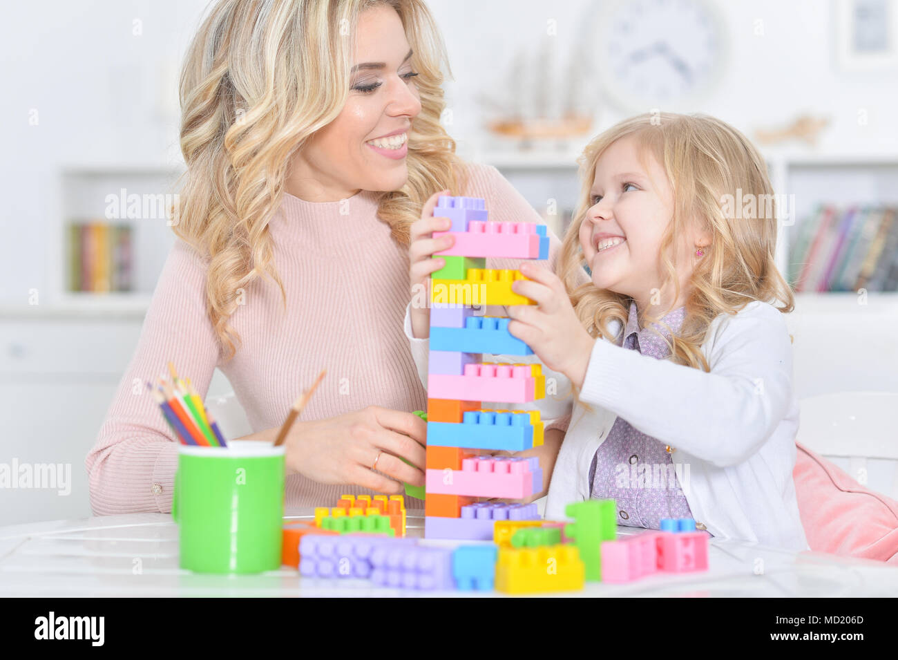 mother with little daughter making figures with constructor Stock Photo