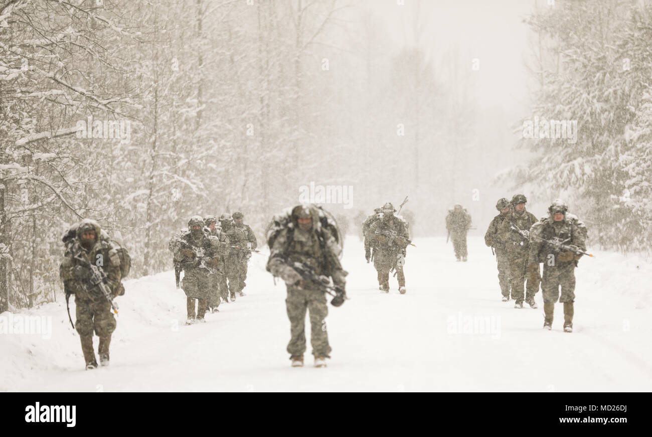 Soldiers assigned to 2nd Battalion, 22nd Infantry Regiment, 1st Brigade Combat Team, 10th Mountain Division (LI), ruck march down a snowy road toward their objective point during Mountain Peak here at Fort Drum, 14 March, 2018. 1BCT is supporting 2nd Brigade Combat Team by operating as oppositional forces for the exercise, thereby providing 2BCT with the training for their next rotation to the Joint Readiness Training Center at Fort Polk, La. (U.S. Army photo by SSG James Avery, 1BCT PAO NCOIC) Stock Photo
