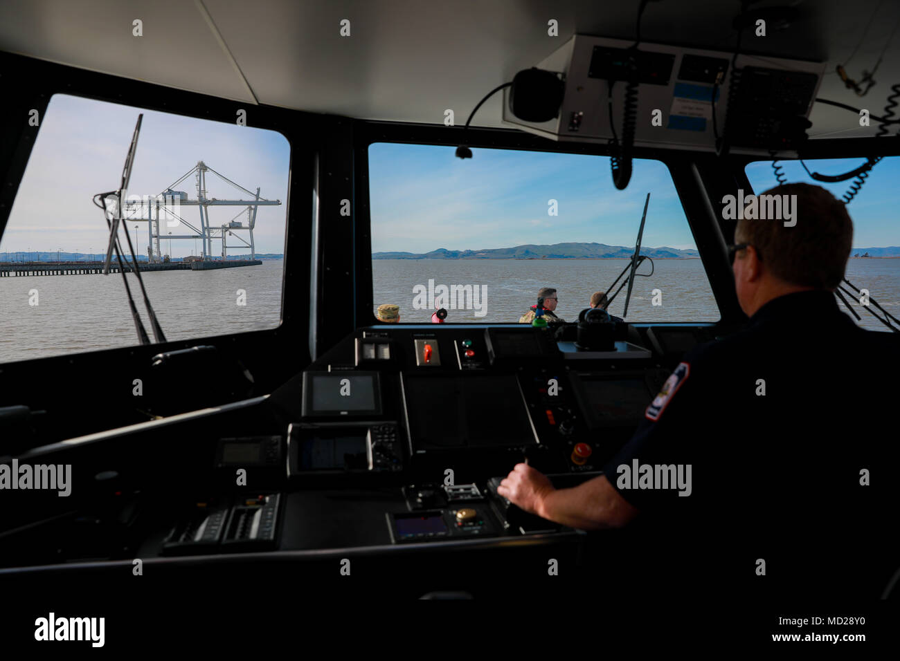 An pier-side firefighter drives one of two U.S. Army fire boats during Operation Trans Mariner 18 West at Military Ocean Terminal Concord, California, Mar. 6, 2018. Trans Mariner 18 West is a real-world strategic mission utilizing U.S. Army Reserve, National Guard and Active component Soldiers to conduct Port Operations allowing Army materiel and munitions containers for travel onward.    (U.S. Army photo by Sgt. Eben Boothby) Stock Photo
