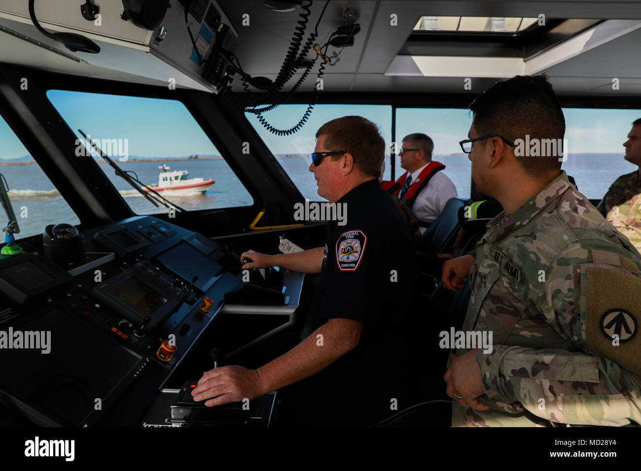 A pier-side firefighter drives one of two U.S. Army fire boats during Operation Trans Mariner 18 West at Military Ocean Terminal Concord, California, Mar. 6, 2018. Trans Mariner 18 West is a real-world strategic mission utilizing U.S. Army Reserve, National Guard and Active component Soldiers to conduct Port Operations allowing Army materiel and munitions containers for travel onward.    (U.S. Army photo by Sgt. Eben Boothby) Stock Photo