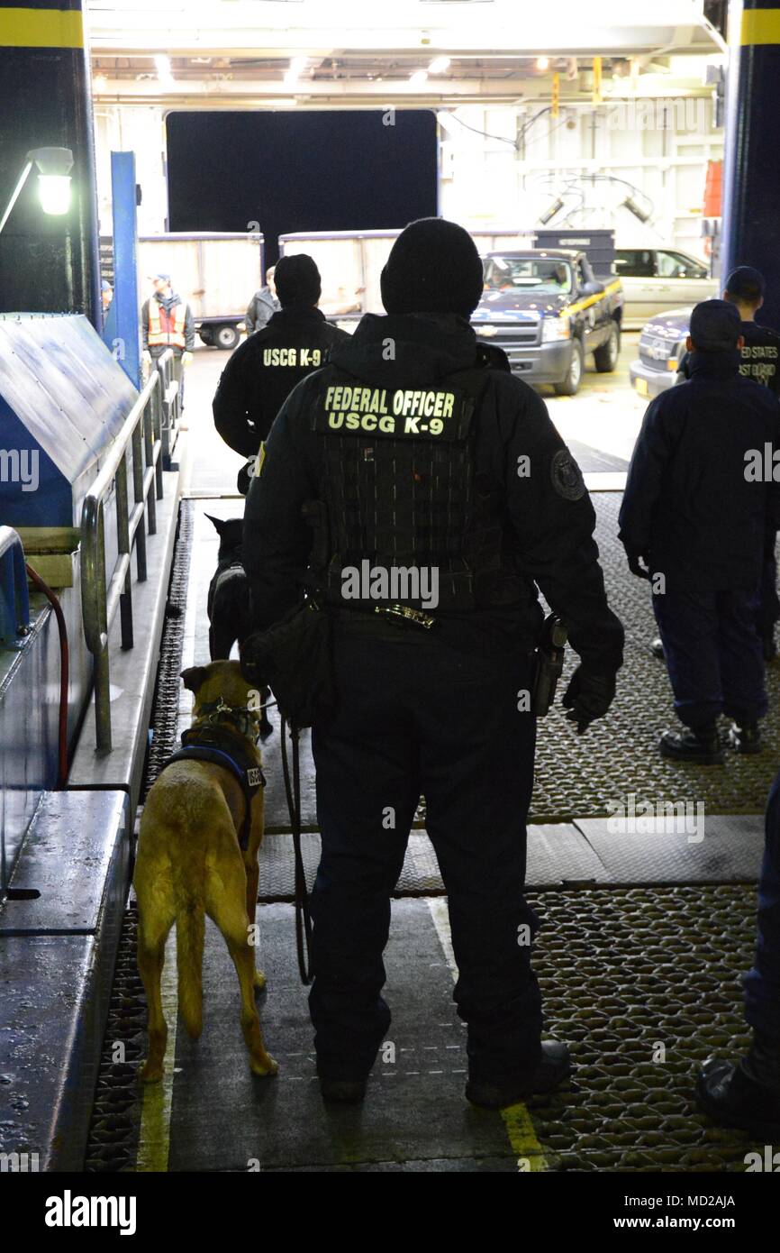Canine Ricky and his handler Petty Officer 1st Class Jordan Brosowsky, from Coast Guard Maritime Safety and Security Team San Francisco (91105), prepare to board the Alaska Marine Highway System ferry Columbia during a joint law enforcement operation in Juneau, Alaska, March 12, 2018. The Coast Guard, Alaska State Troopers and Juneau Police Department partnered together during the law enforcement operation to detect and deter illegal activity on Alaska's waterways. U.S. Coast Guard photo by Lt. Brian Dykens. Stock Photo