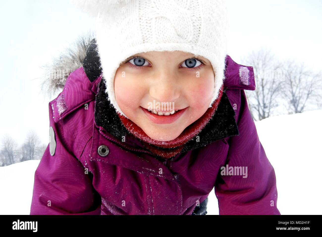 Baby girl having fun in the snow on a winter background. Stock Photo