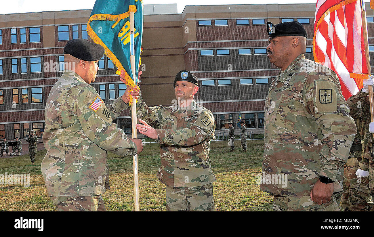 FORT LEE, Va. (March 28, 2018) -- Col. Jamal E. Wigglesworth, Army Logistics University commandant, left, passes the newly uncased colors of the ALU Support Battalion to Lt. Col. Matthew K. Anastasi during the 71st Transportation Bn. in-activation ceremony March 28 in the ALU Quad area.  Also pictured is Command Sgt. Maj. Leabarron J. Bates who helped uncase the Support Bn., colors and will serve as its CSM alongside Anastasi, the commander. The brick red and yellow colors of the 71st Trans. Bn.,  arrived here in 2010 when it replaced the Student Officer Bn. that was stood up when ALU opened i Stock Photo