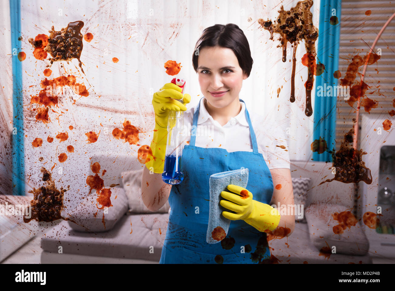 Smiling Female Janitor Cleaning Dirty Glass Window With Spray Stock Photo