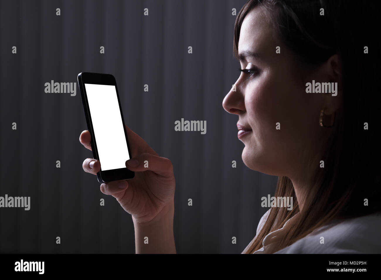 Young Woman Using Mobile Phone With Blank White Screen Stock Photo