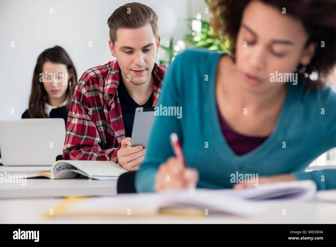 Student smiling while using a tablet during class Stock Photo