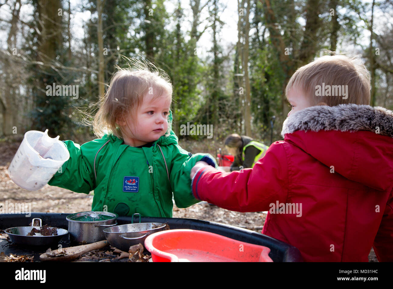 Toddlers playing with a mud kitchen Stock Photo