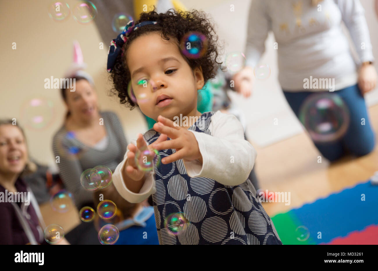 Toddler playing with bubbles Stock Photo