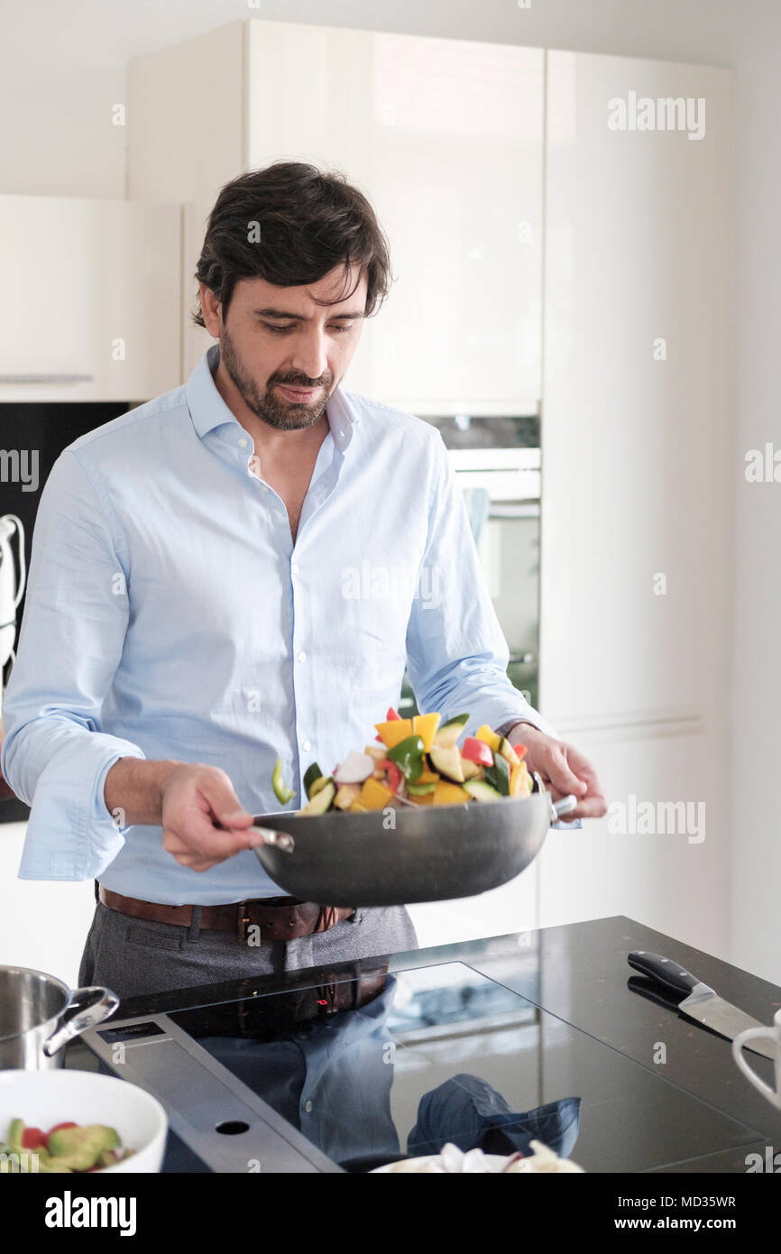 30-35 years old latin man  cooking vegetarian food Stock Photo