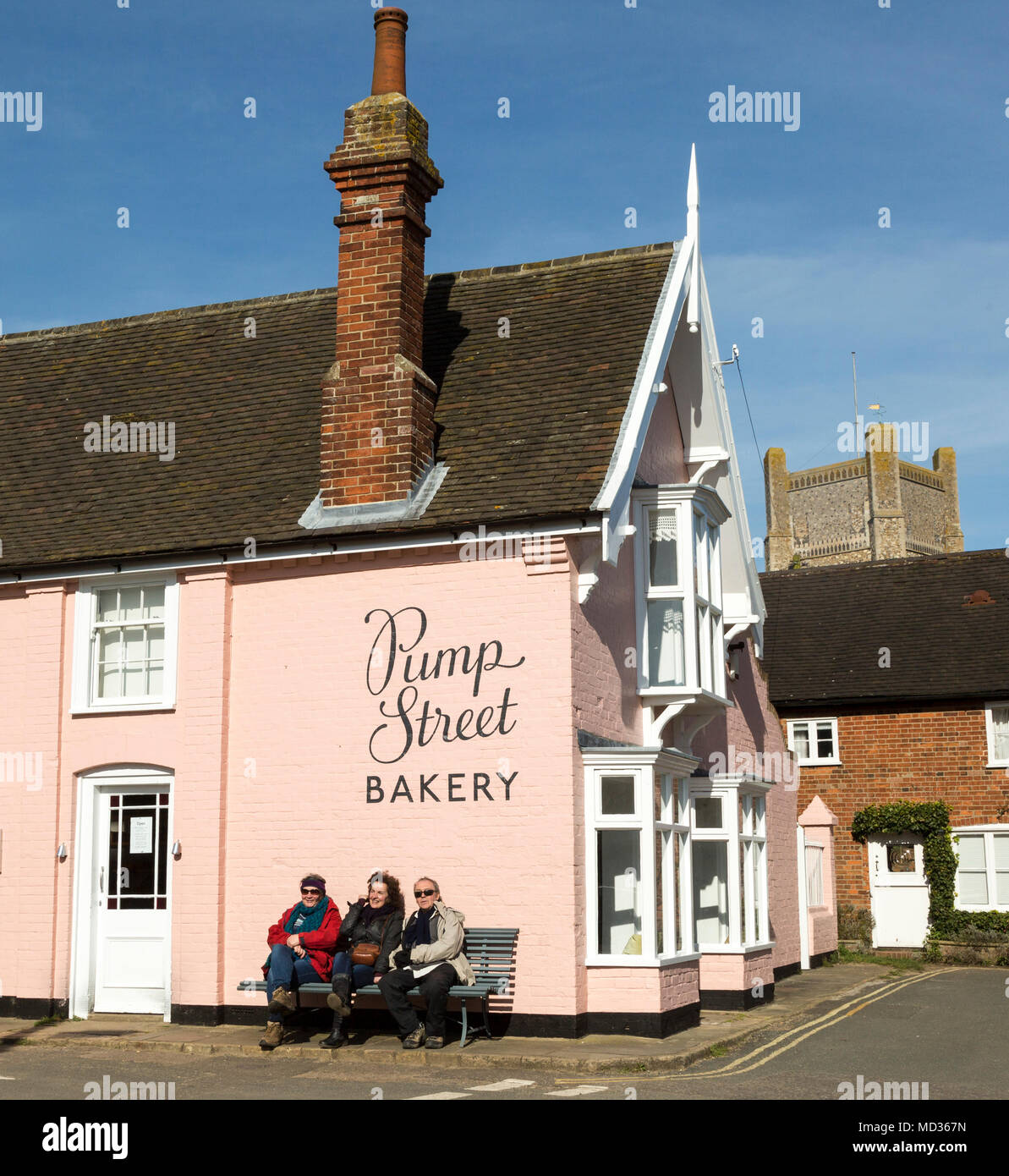 People sitting outside on sunny winter day Pump Street bakery, Orford, Suffolk, England, UK Stock Photo