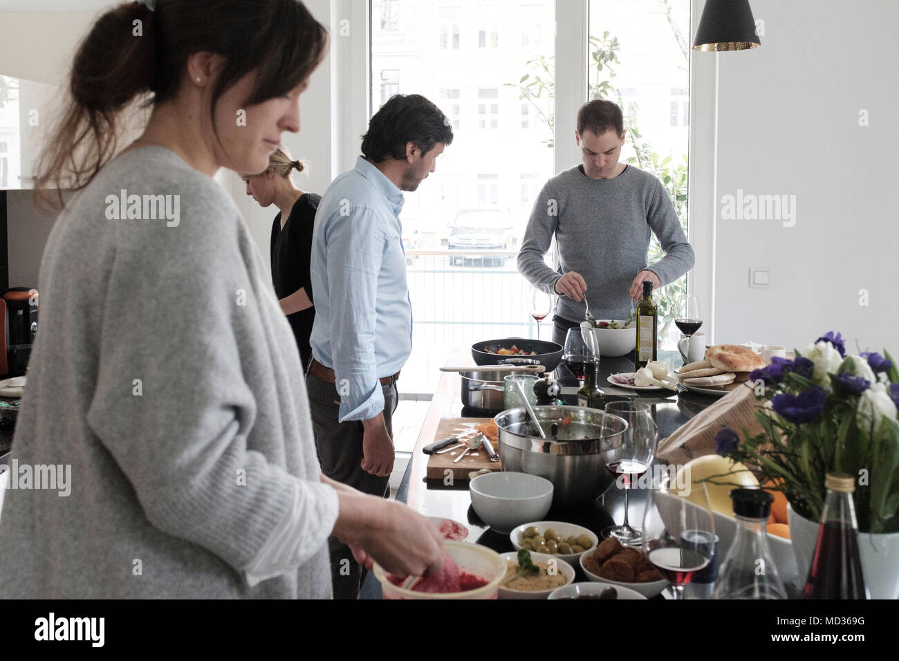Group of friends casually snacking on a selection of food while laughing and enjoying themselves. Stock Photo