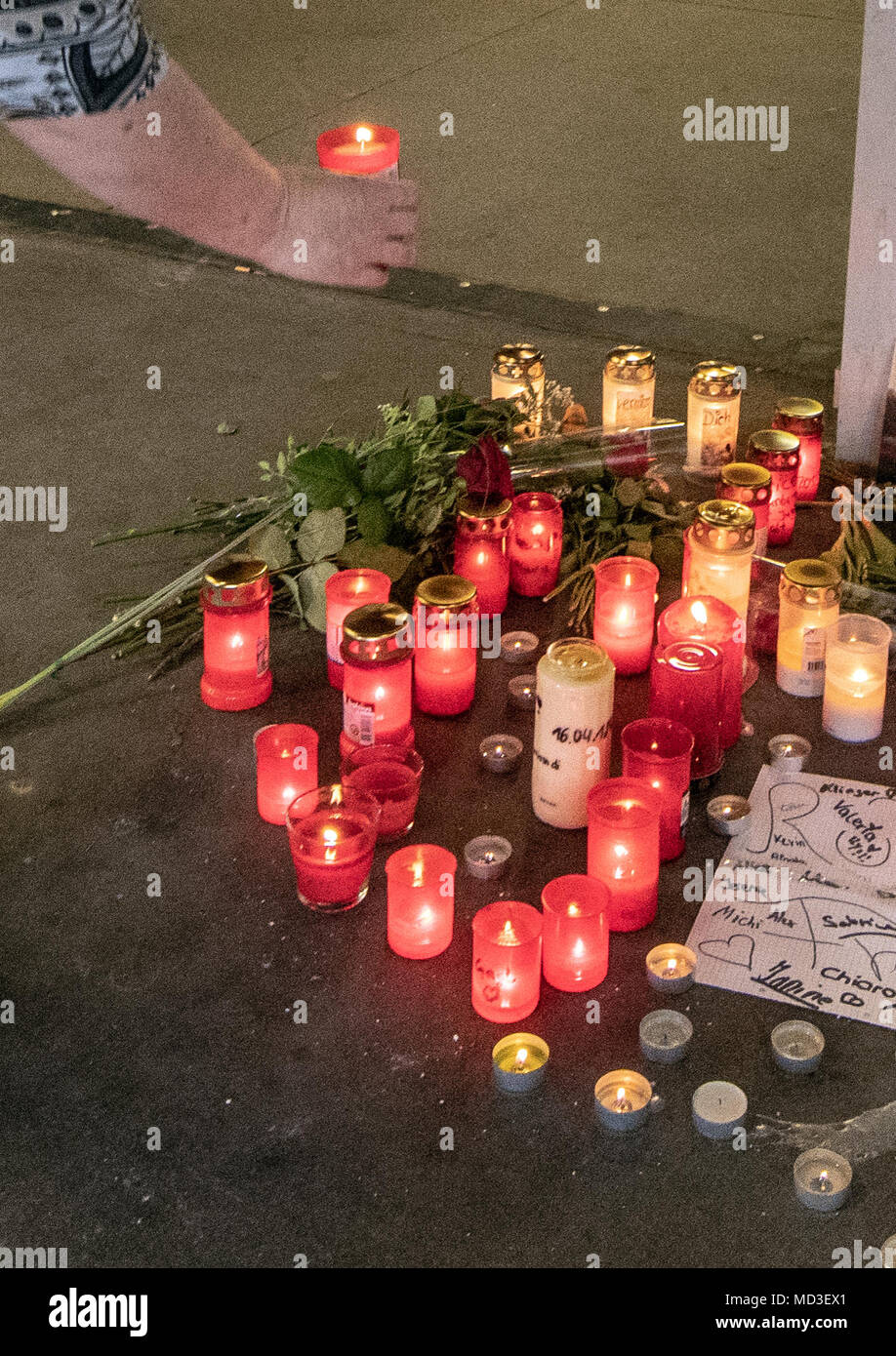 18 April 2018, Passau, Germany: A woman places a candle at the crime scene. According to an autopsy report by the police on Wednesday, the boy suffocated on his own blood during the fight an underground pedestrian passageway. Photo: Armin Weigel/dpa Stock Photo