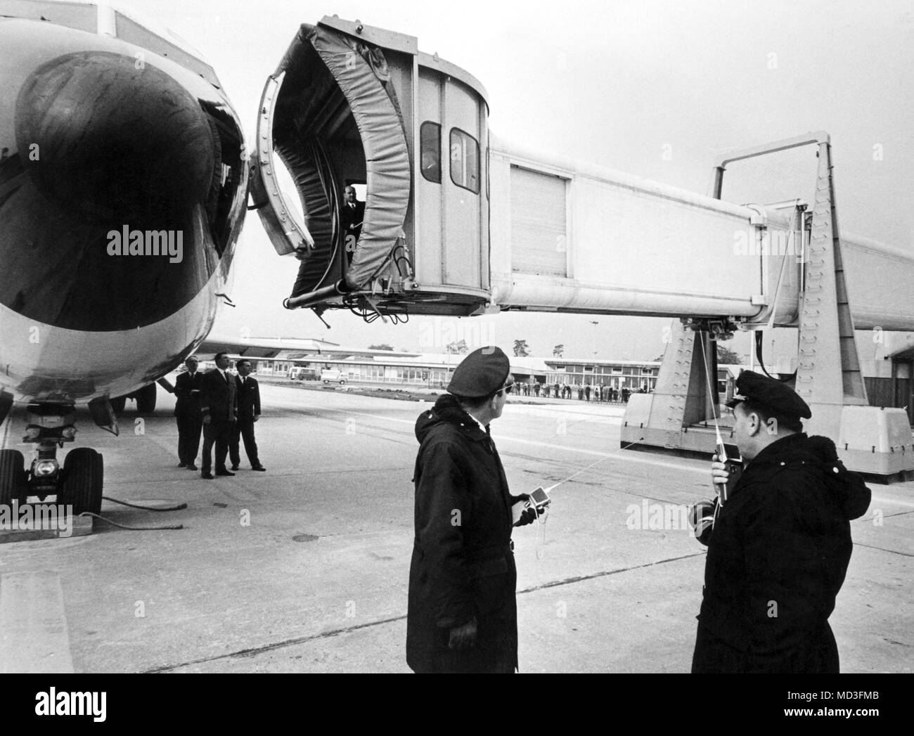 The swiveling connection piece of the telescopic passenger bridge is moved up to the machine. On November 11, 1966, a passenger bridge is inaugurated at Frankfurt Rhein-Main Airport, which can be extended telescopically. Through them, the passengers get protected from any weather directly from the terminal building in the plane, or after landing from the plane to the airport. Lastiges and time-consuming stair climbing omitted. Photo: Roland Witschel     (c) dpa - Report     | usage worldwide Stock Photo