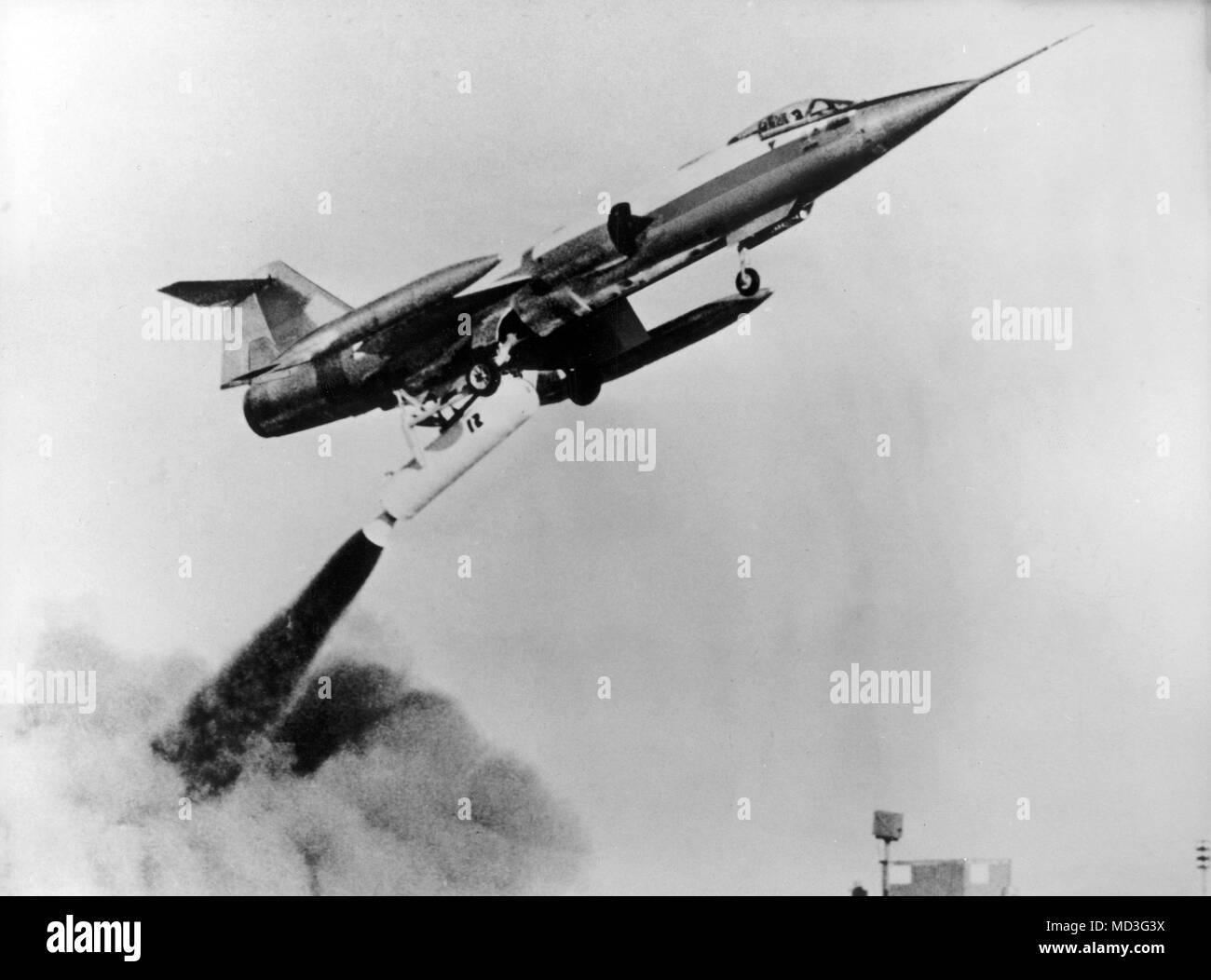 A German Starfighter of the type F 104 G with test pilot Ed Brown shortly after the start with an additional rocket on 18.05.1966 on the air base in Bavarian Lagerlechfeld. On 18.05.1966 a Starfighter zero start of the German press was shown in Lagerlechfeld for the first time. Test pilot was Ed Brown, who was already used in the USA for the zero-start trials. Through a rocket drive set below the fuselage, the Starfighter is fired into the air at a steep angle, where it first fires its own rocket engine. Photo: Jurgen Diener     (c) dpa - Report     | usage worldwide Stock Photo