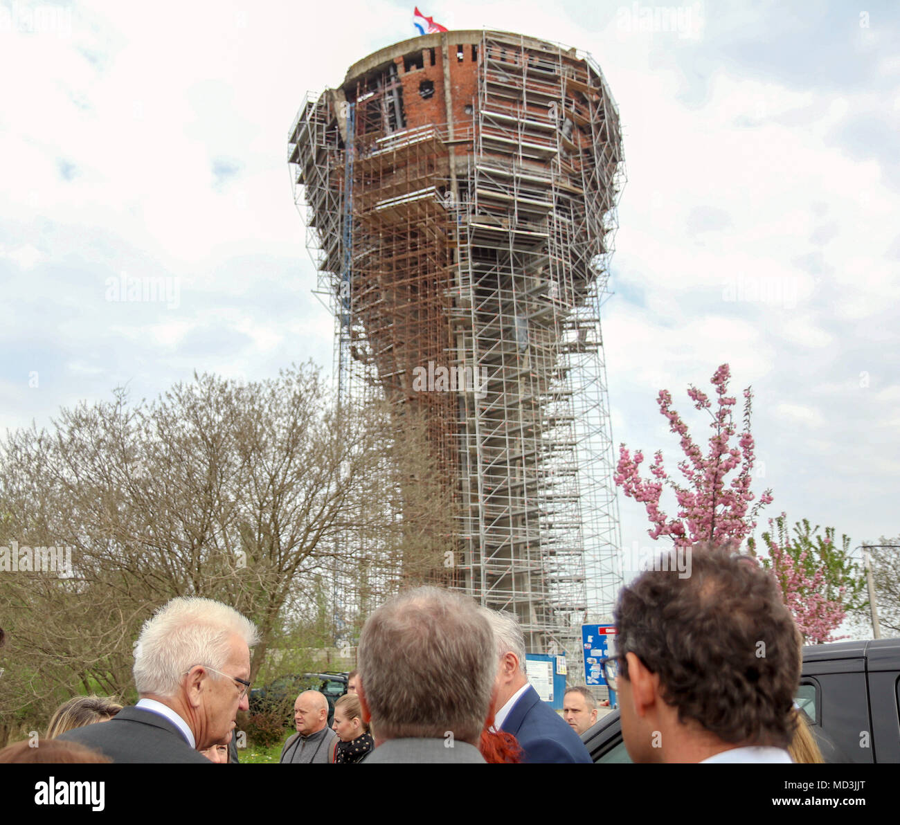 HANDOUT - 18 April 2018, Croatia, Vukovar: Winfried Kretschmann (L) of Alliance 90/The Greens, Premier of Baden-Wuerttemberg, stands in front of the water tower in the course of a visiting. Today, the water tower is a civil war memorial and is being expanded as a memorial site. Photo: Jana Höffner/Staatsministerium Baden-Württemberg/dpa - ATTENTION: editorial use only in connection with the latest coverage about (the transmission/the film/the auction/the exhibition/the book) and only if the credit mentioned above is referenced in full Stock Photo