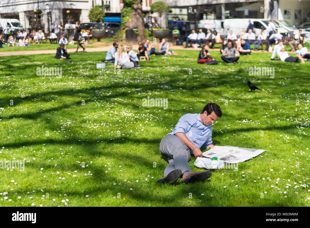 Office workers enjoy the warm spring weather at lunchtime in Berkeley Square in London, where temperatures rose as high as 26 degrees. Photo date: Wednesday, April 18, 2018. Photo: Roger Garfield/Alamy Live News Stock Photo