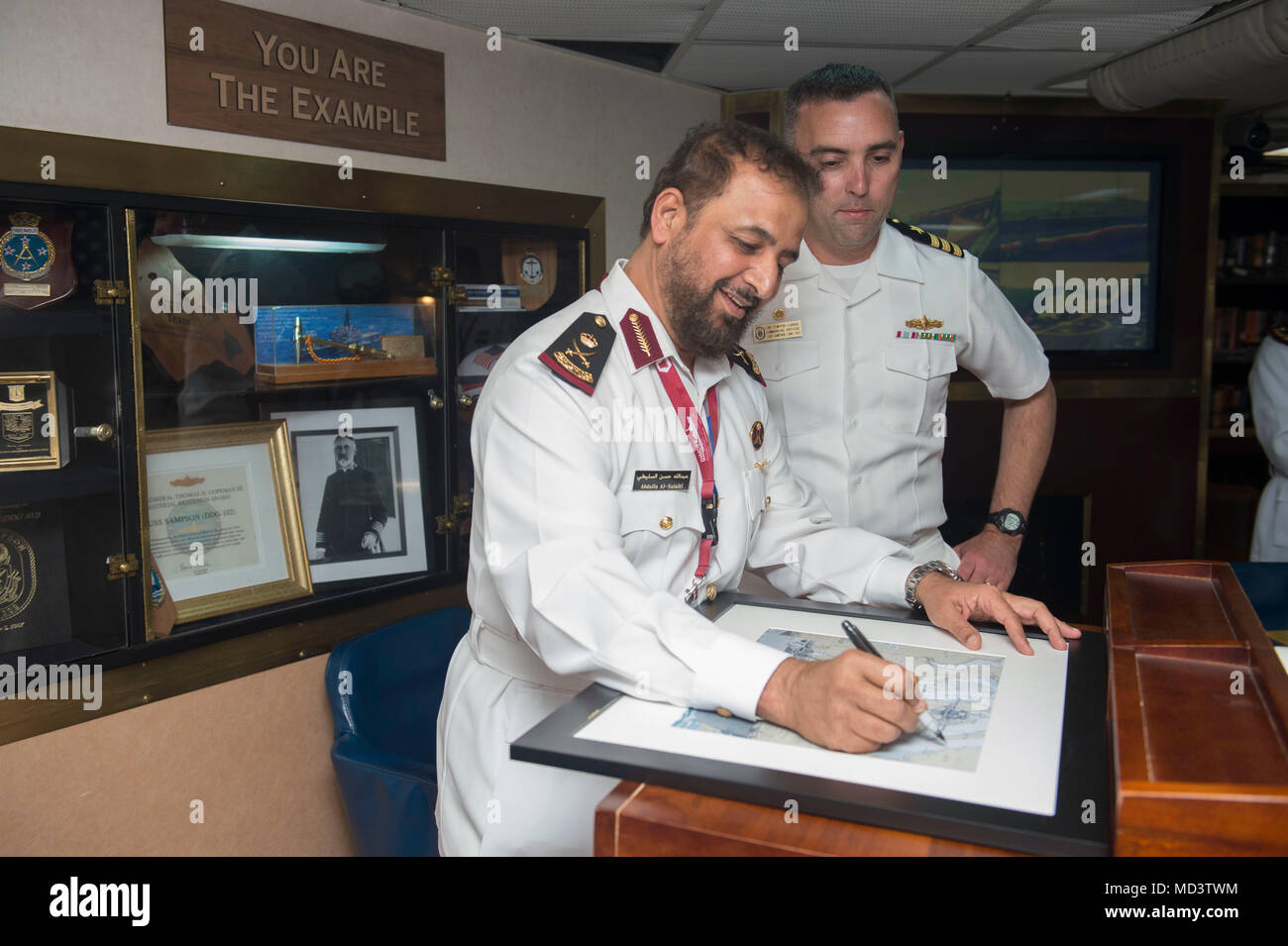 180311-N-OI558-1113 DOHA, Qatar (March 11, 2018) Maj. Gen. Abdulla bin Hassan Al Sulaiti, commander of the Qatar Emiri Naval Forces signs a portrait during his visit aboard the Arleigh Burke-class guided-missile destroyer USS Sampson (DDG 102). Sampson is deployed with the Theodore Roosevelt Carrier Strike Group to the U.S. 5th Fleet area of operations in support of maritime operations to reassure allies and partners and preserve the freedom of navigation and the free flow of commerce in the region. (U.S. Navy photo by Mass Communication Specialist 3rd Class Chanel L. Turner/Released) Stock Photo