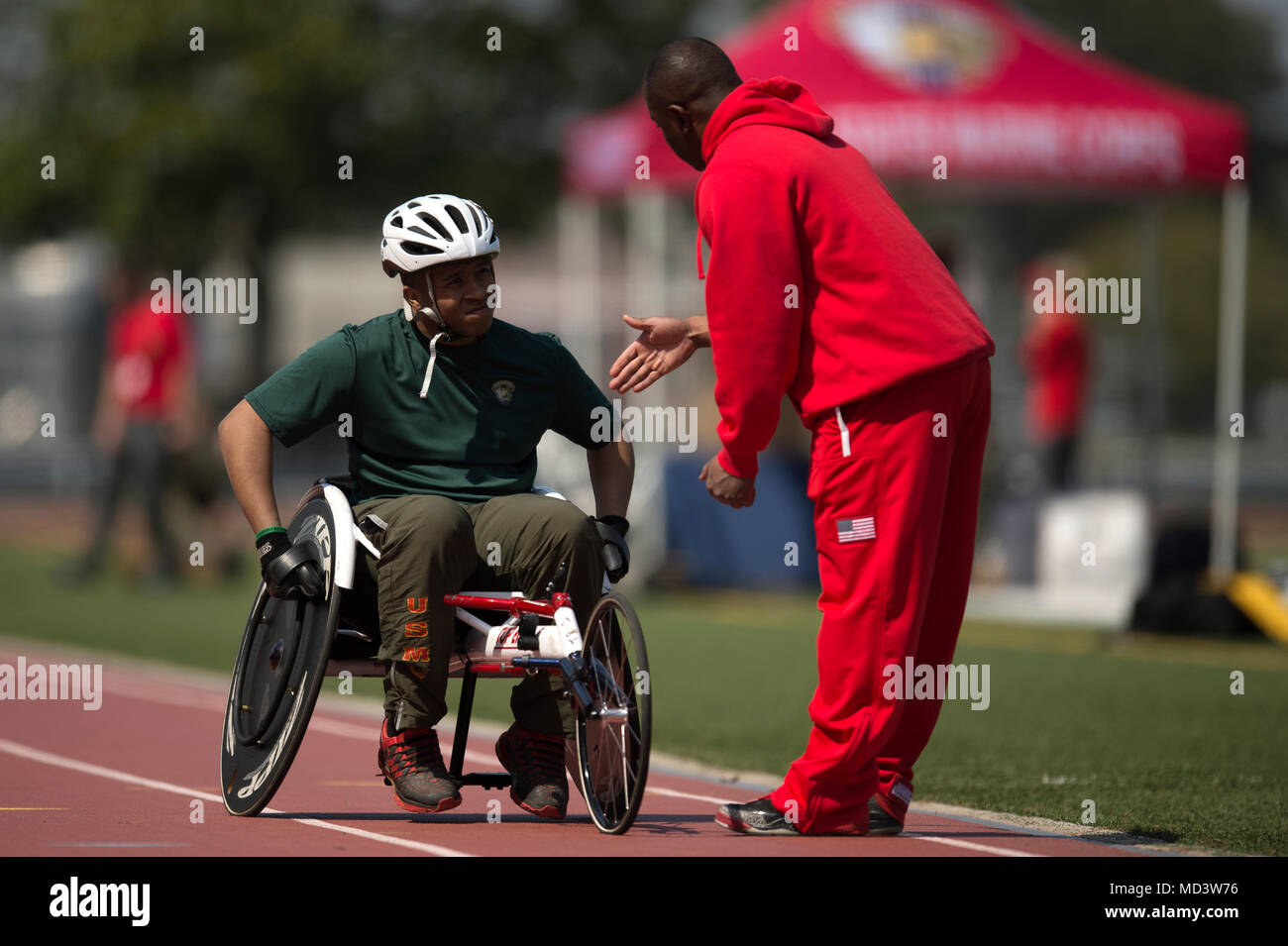 U.S. Marine Corps Cpl. Oscar Jordan takes instruction from U.S. Marine Corps Staff Sgt. Michael Pride, during a 2018 Marine Corps Trials track and field practice at Marine Corps Base Camp Lejeune, N.C., March 16, 2018. Jordan is a member of the 2018 Marine Corps Trials Wounded Warrior Battalion-East Team. Pride is a track and field coach for the 2018 Marine Corps Trials. The Marine Corps Trials promotes recovery and rehabilitation through adaptive sport participation and develops camaraderie among recovering service members (RSMs) and veterans. It is as an opportunity for RSMs to demonstrate t Stock Photo