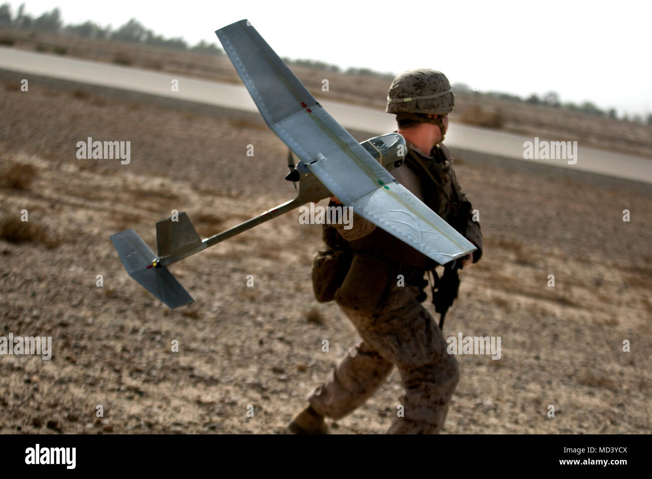A U.S. Marine with Task Force Southwest (TFSW) tosses a RQ-11B Raven unmanned aerial system (UAS) during a security patrol near Bost Airfield, Afghanistan, March 12, 2018. Marines with TFSW use UAS assets to assist the Afghan National Defense and Security Forces in surveillance operations to increase their combined capabilities in Helmand province. (U.S. Marine Corps photo by Sgt. Sean J. Berry) Stock Photo