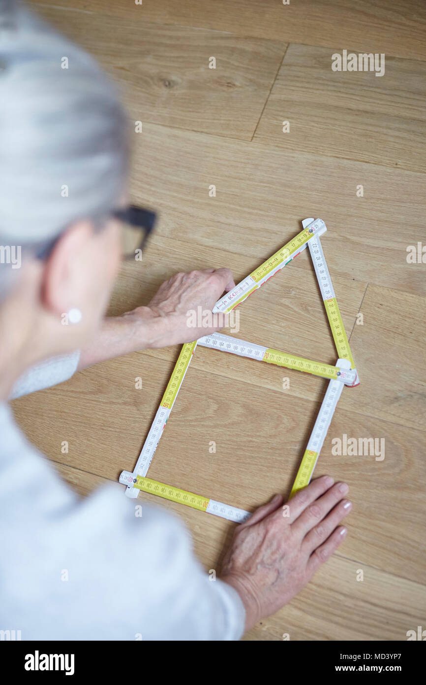 Woman with house shaped tape measure on floor Stock Photo Alamy