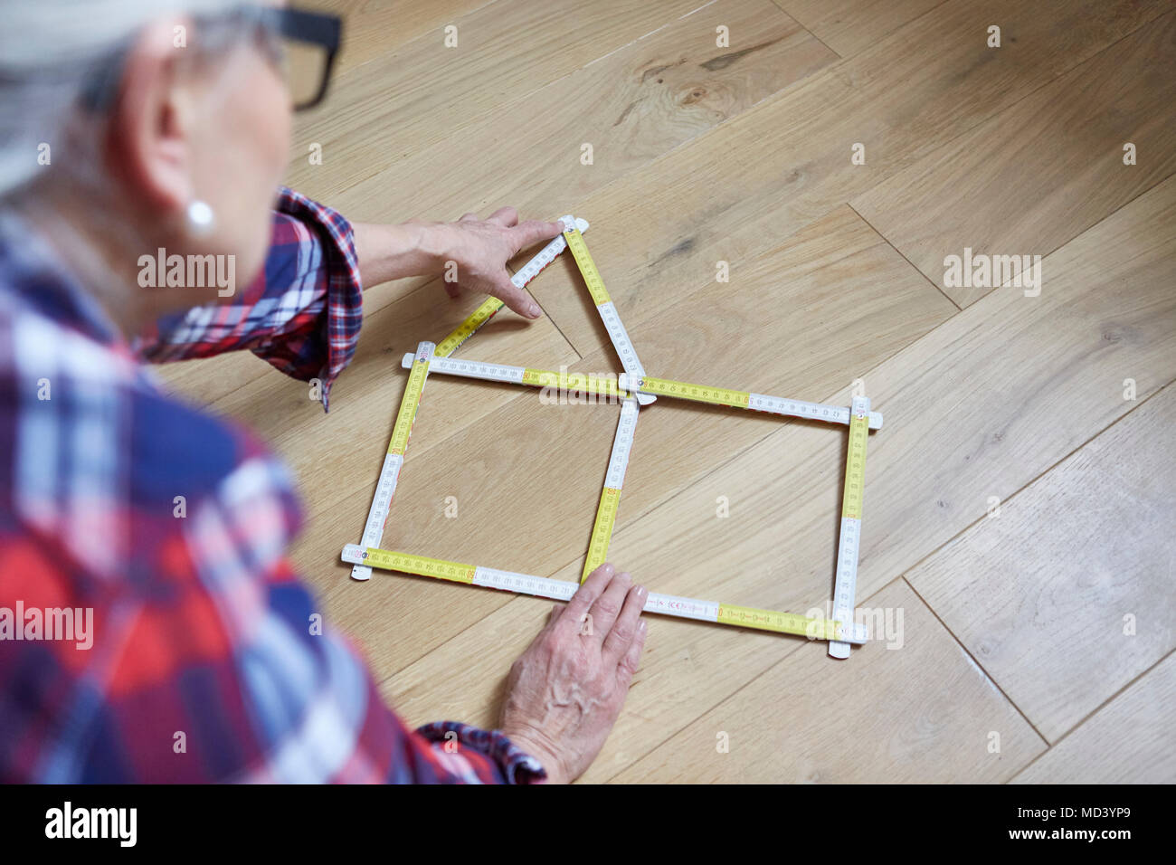 Woman with house shaped tape measure on floor Stock Photo Alamy