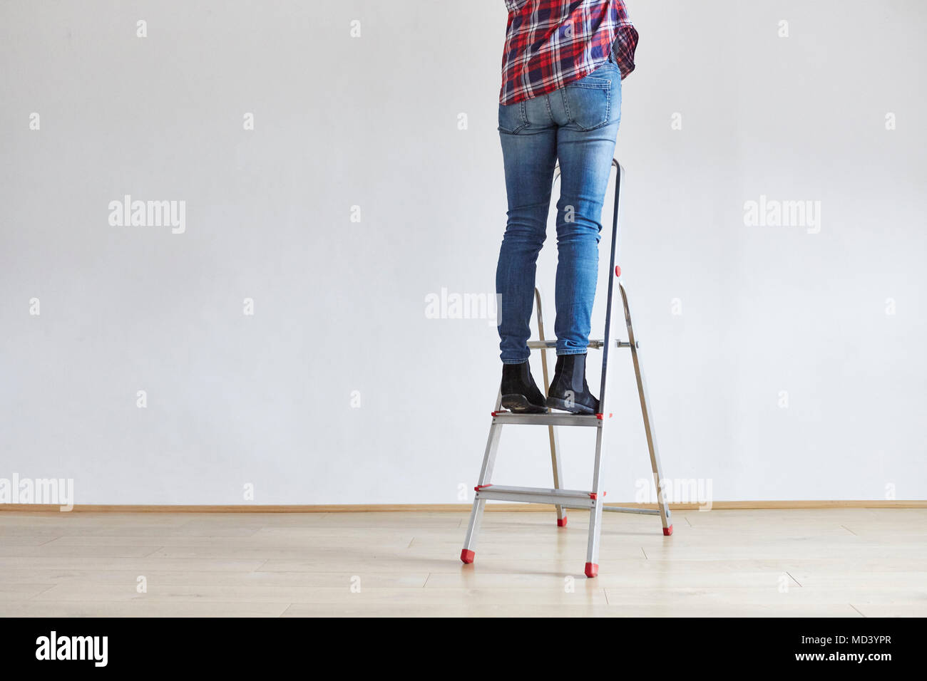 Person standing on ladder Stock Photo