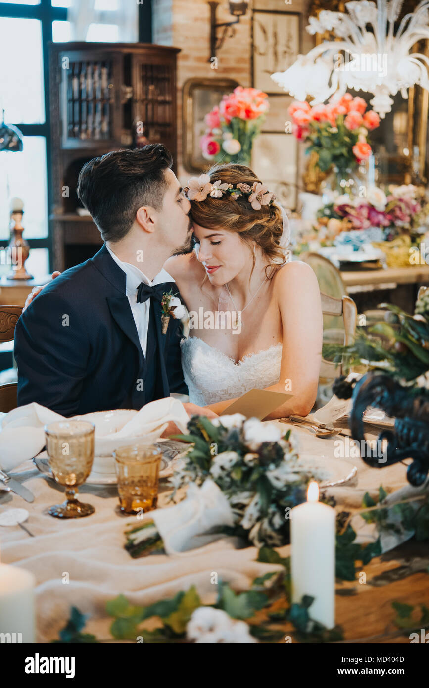 Bride and bridegroom seated at table at wedding reception Stock Photo