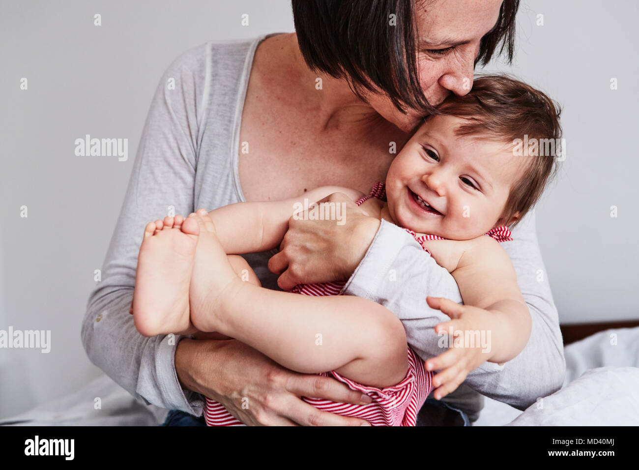 Portrait of mother, hugging baby daughter Stock Photo