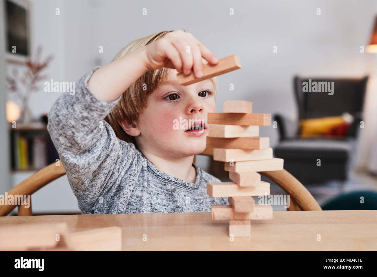 Portrait of young boy, building structure with wooden building blocks Stock Photo
