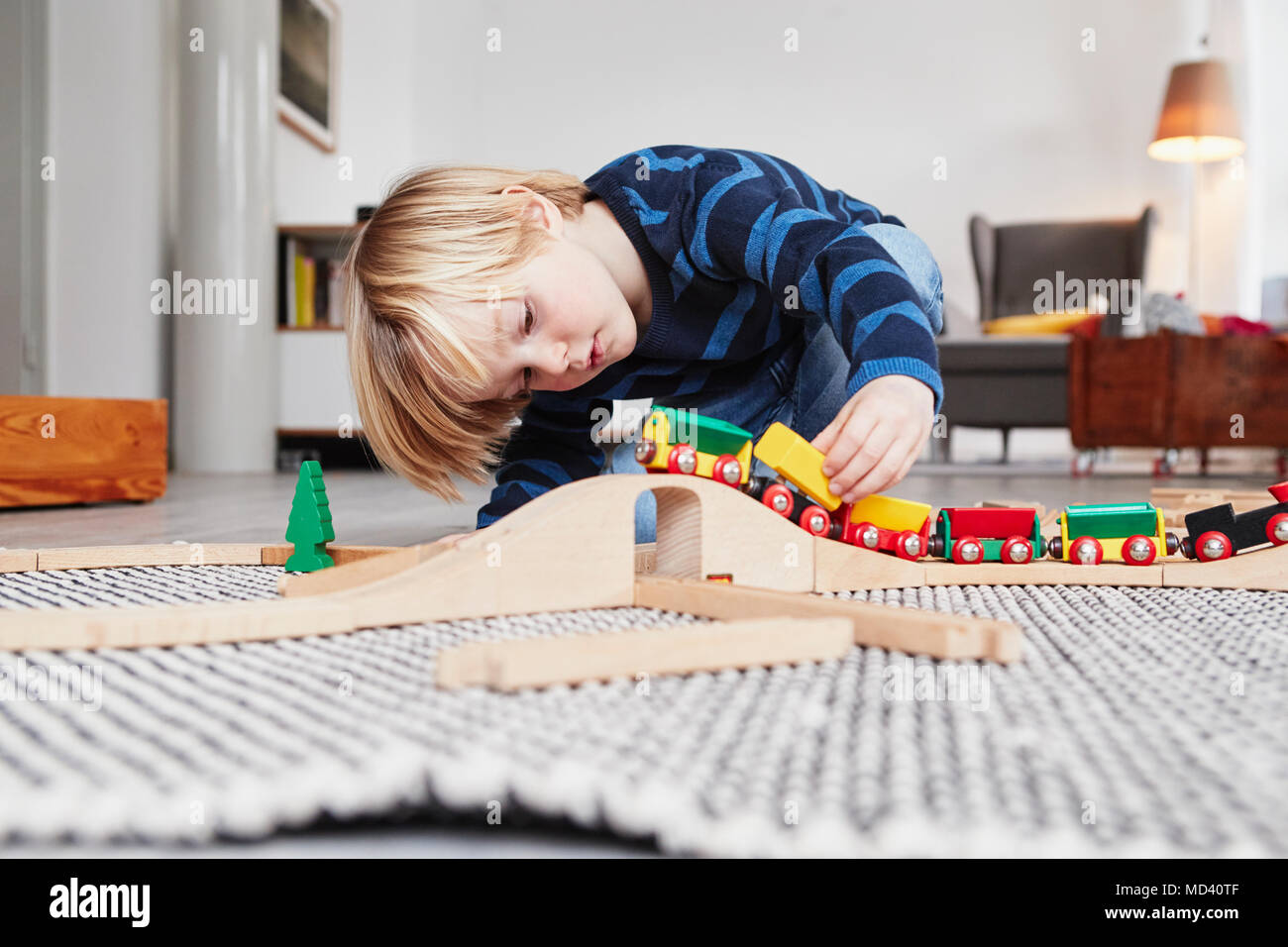 Young boy playing with toy train and track Stock Photo