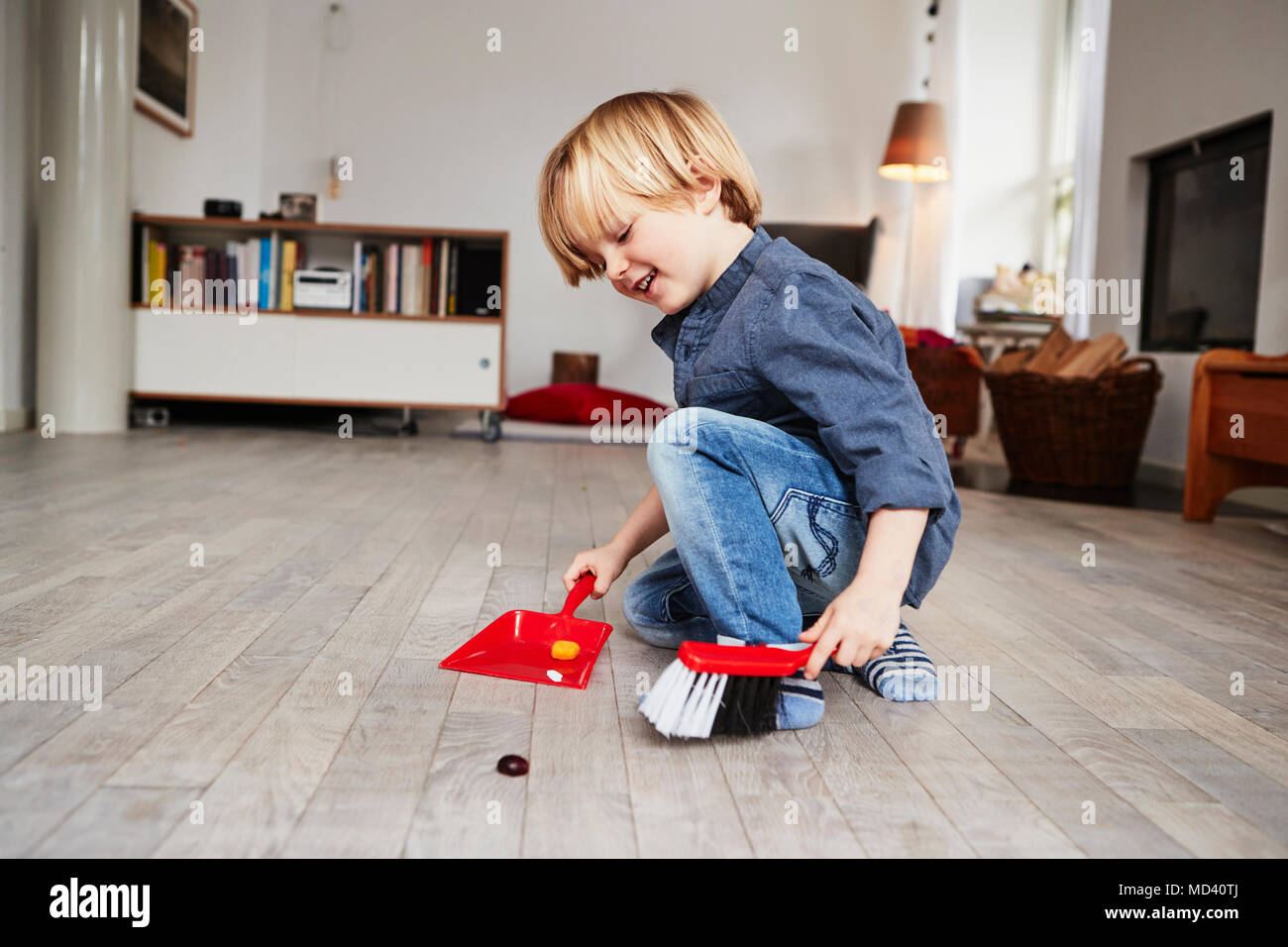 Young boy playing with toy dustpan and brush Stock Photo