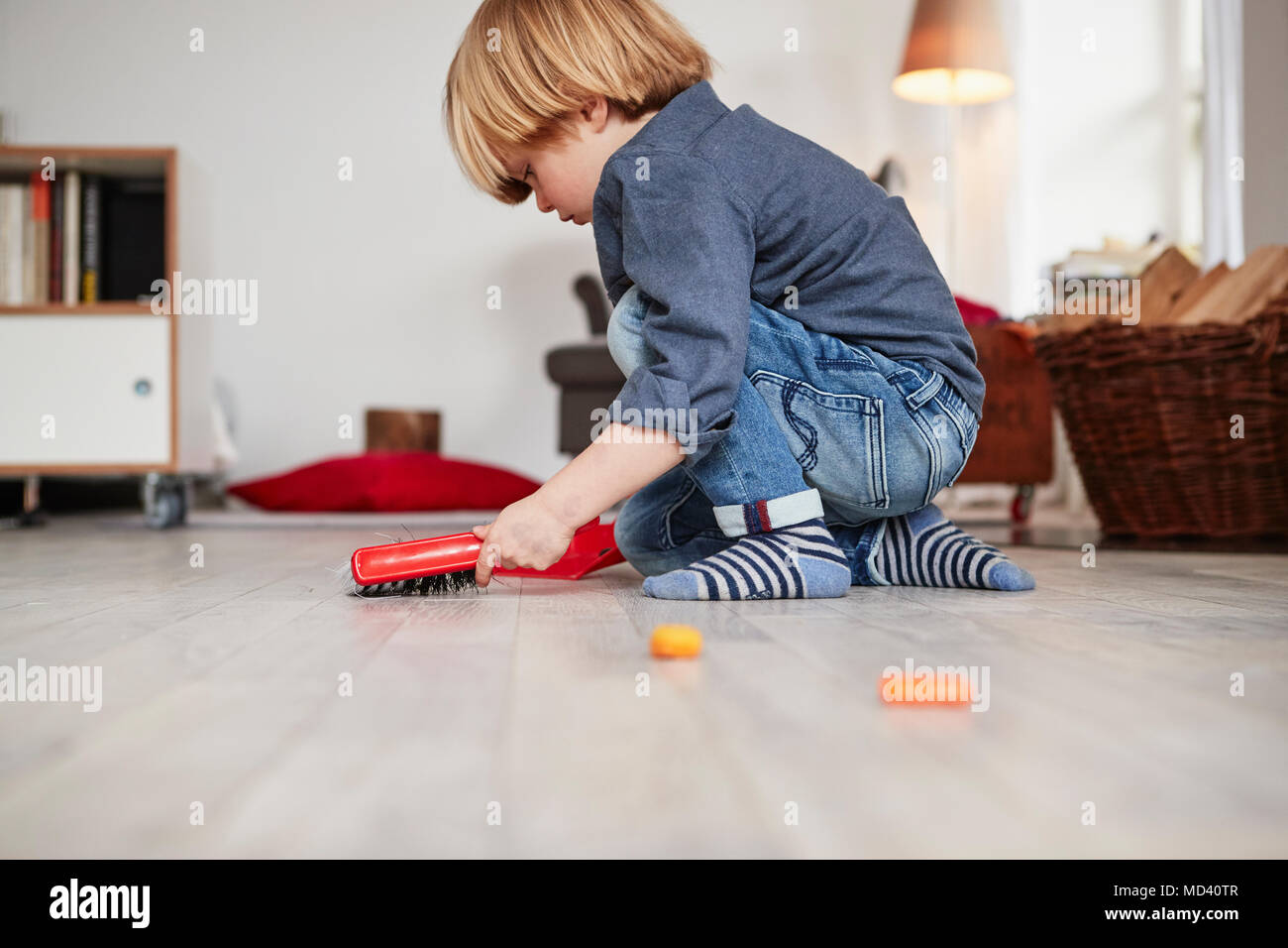Young boy playing with toy dustpan and brush Stock Photo