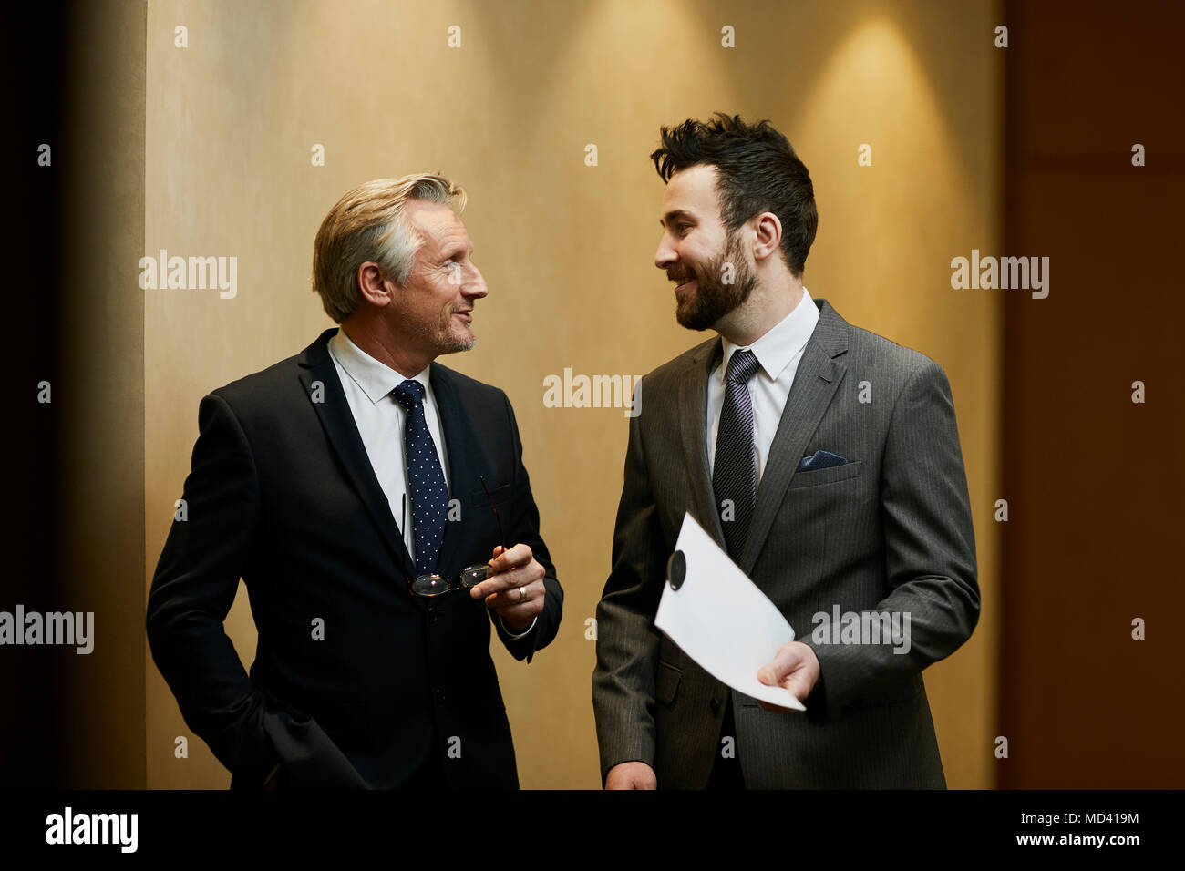 Two businessmen talking in office corridor Stock Photo