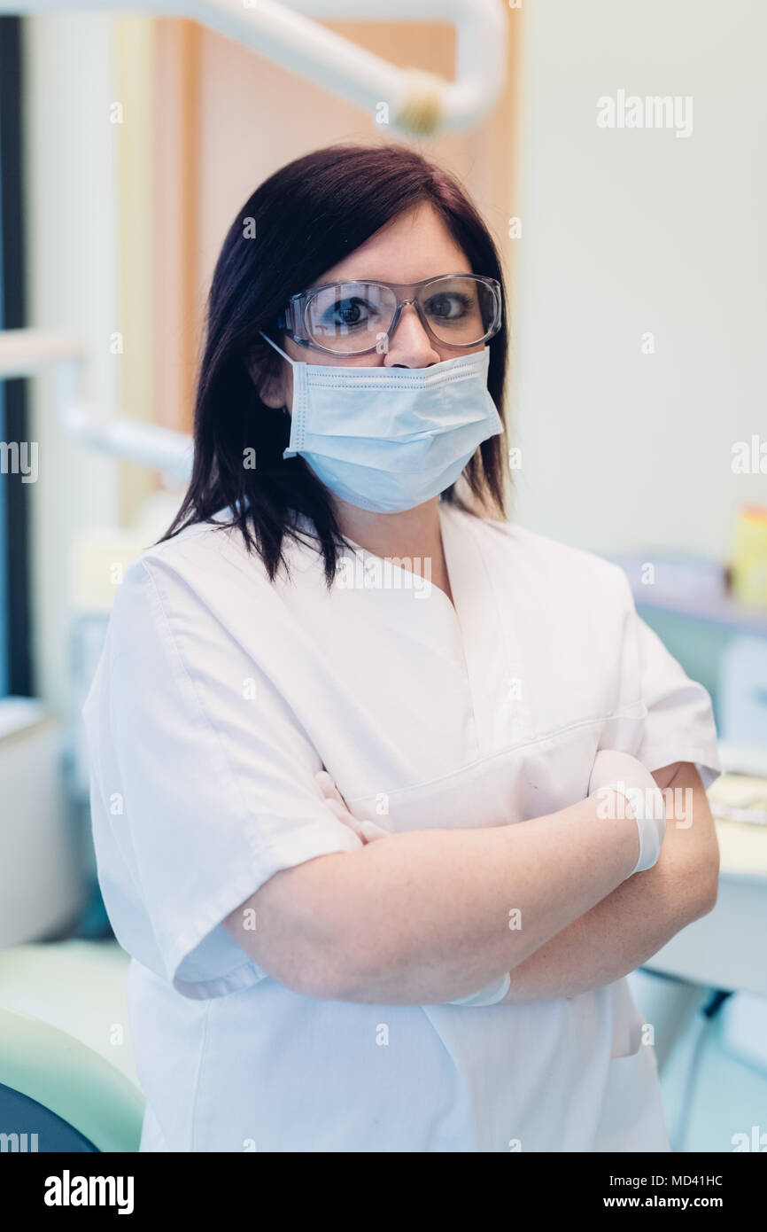 Portrait of female dentist, wearing surgical mask, in dentist office Stock Photo