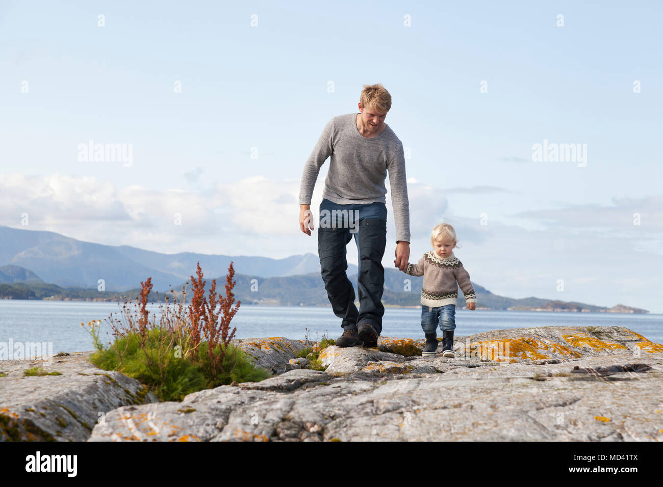 Man and son strolling by fjord, Aure, More og Romsdal, Norway Stock Photo
